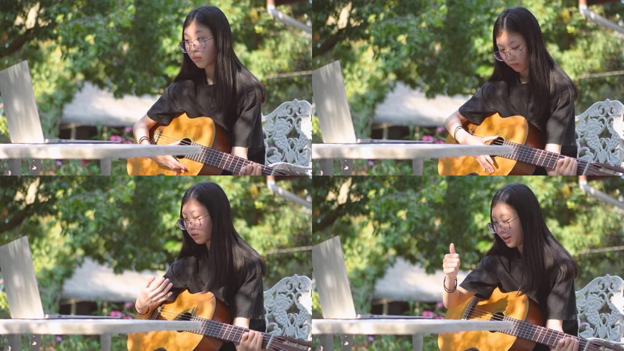 亚洲少女在后院通过在线教练学习吉他