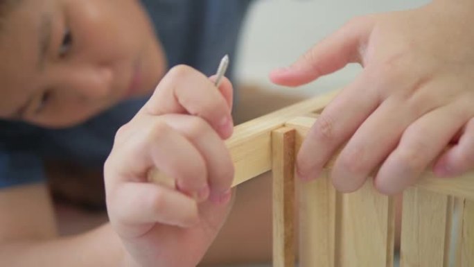 亚洲男孩学习如何DIY木制架子。