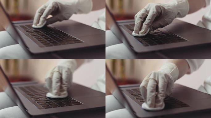 使用抗菌湿巾消毒笔记本电脑库存视频的女人的手戴手套的特写视图