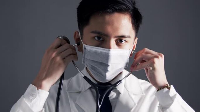 亚洲年轻医生穿白色医用大衣手持听诊器