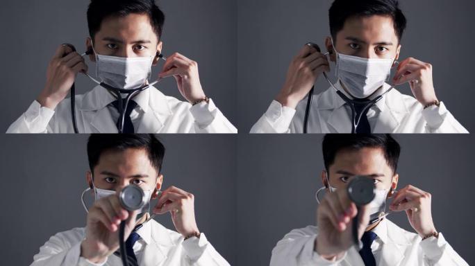 亚洲年轻医生穿白色医用大衣手持听诊器