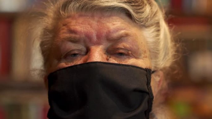 脸上戴着无菌医用口罩的老人看着相机