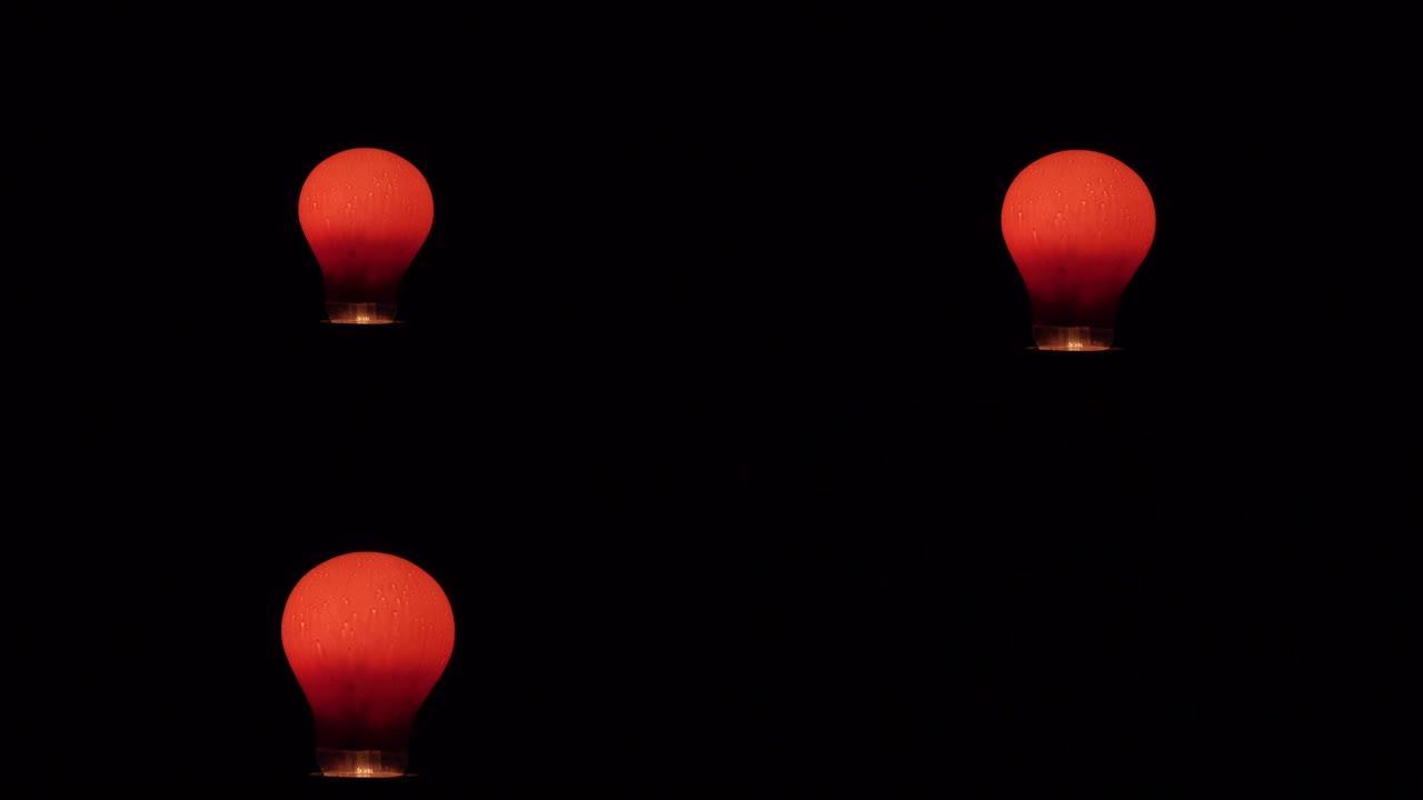 灯泡在黑暗中是红色的。闪闪红色。电。