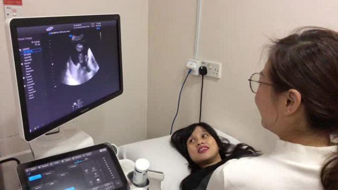 亚洲中国年轻医生在医院的医生室为孕妇进行超声检查