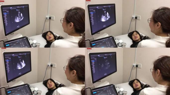 亚洲中国年轻医生在医院的医生室为孕妇进行超声检查