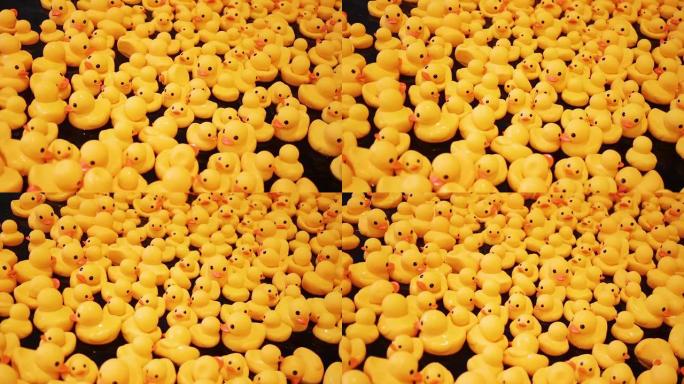 大量的黄色橡皮鸭在黑暗的水中游泳