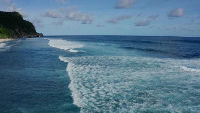 鸟瞰海洋，美丽的泡沫滚滚波浪，背景上的山