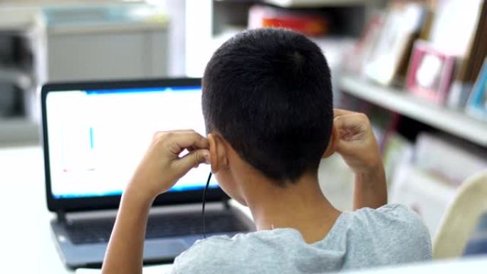 一个亚洲男孩在家在线学习。在全球流行病2020新型冠状病毒肺炎疫情的关键爆发期间