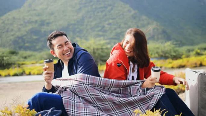快乐的亚洲夫妇露营和喝咖啡与自然背景，生活方式的概念。