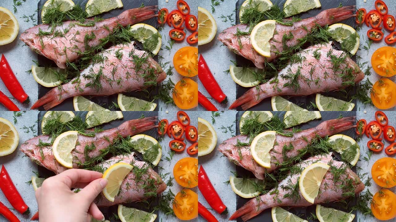 生鱼和供烘烤的蔬菜一起鲈鱼。厨师将柠檬片放在鱼的胴体上，以便在烤箱中烹饪
