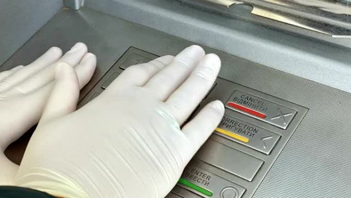 女性手在ATM键盘上输入PIN码。