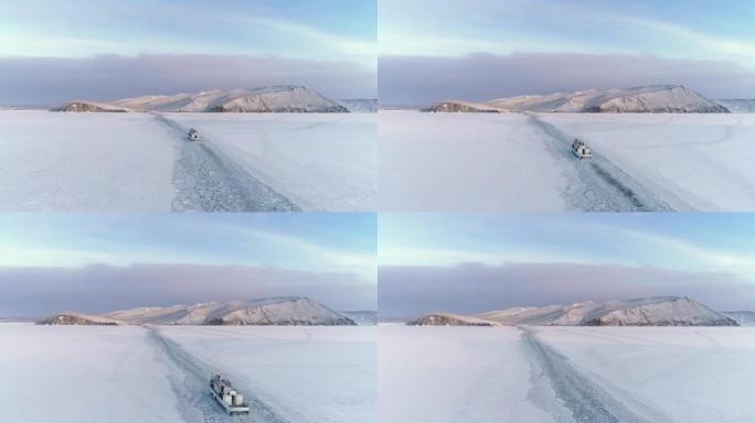 空中船沿着冰冻的贝加尔湖空雪覆盖的表面漂浮。无人机跟随破冰船在冰上移动