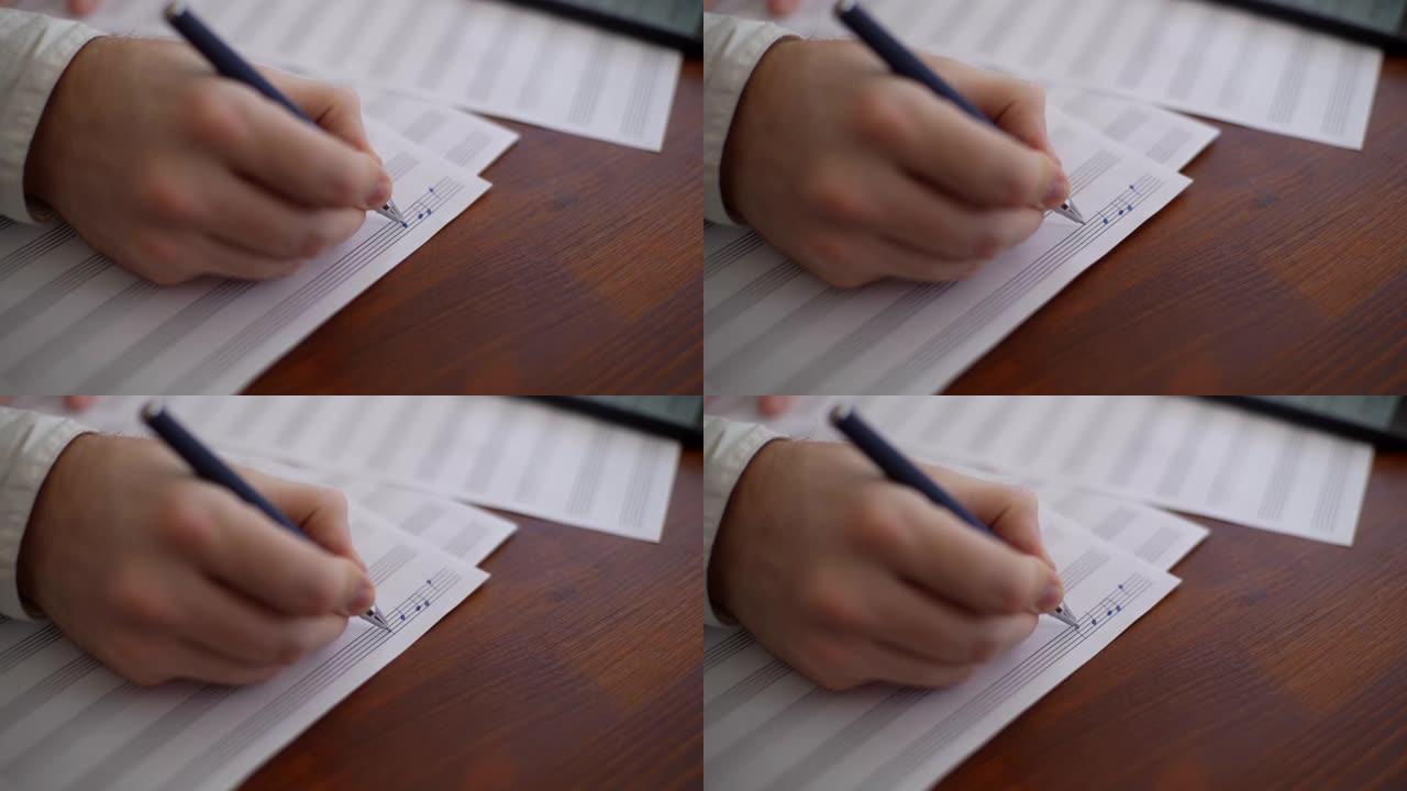 无法辨认的音乐家用笔写音符的手的特写。