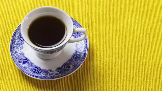 黄色餐垫上的中国瓷器咖啡杯