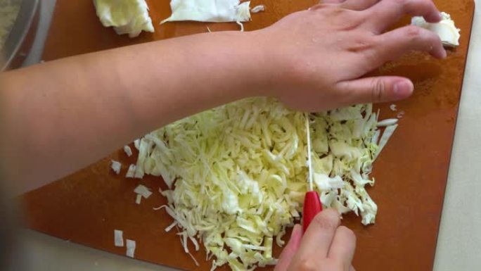 当地生活方式家庭主妇在砧板上切蔬菜卷心菜做沙拉。