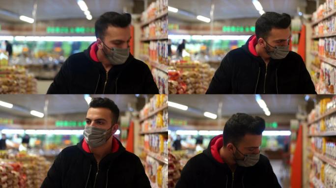 超市里戴着口罩的男子正在寻找消毒剂