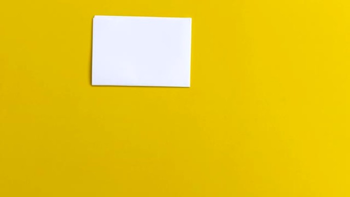 4k停止运动白纸折叠并进入黄色背景上的信封，交流镜头视频概念。