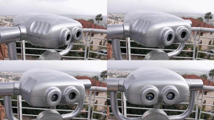旅游望远镜全景双筒望远镜。金属投币操作灰色望远镜孤立在一个美丽的全景风景