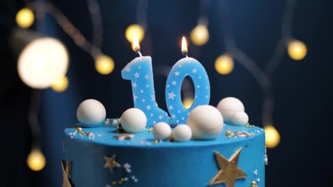 生日蛋糕10号星星天空和月亮概念，蓝色蜡烛被打火机点燃，然后吹灭。如果需要，请在屏幕右侧复制空间。特
