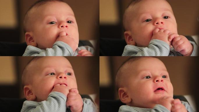 可爱的婴儿肖像脸把手放在嘴里