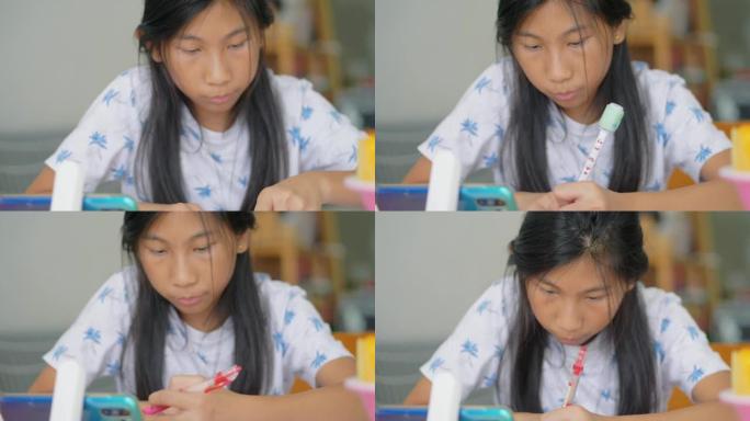 亚洲女孩在冠状病毒期间使用智能手机进行家庭教育概念。