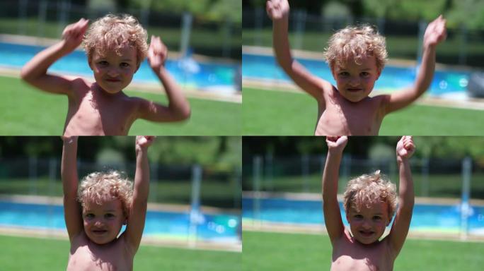可爱的蹒跚学步的男婴在空中举起手臂庆祝
