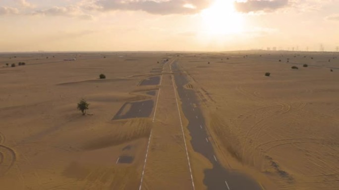 在阿拉伯联合酋长国或阿联酋的迪拜市，半沙漠道路或沙丘街道的鸟瞰图。日落时的自然景观背景。著名的旅游景