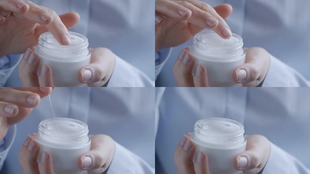 女人的手从瓶子里取出蜗牛霜，轻轻地放在脸上