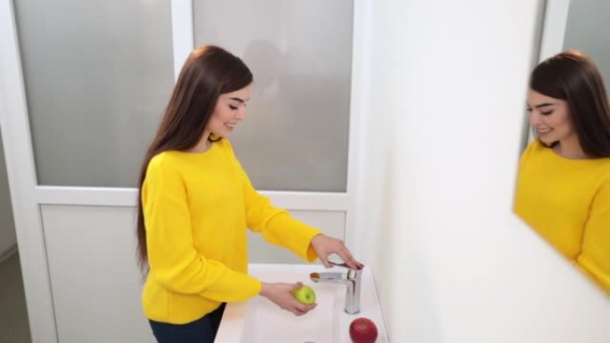 女人走到脸盆前打开水，洗青苹果