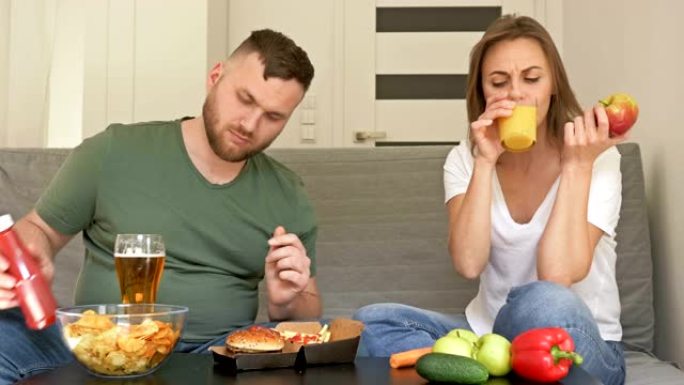 健康和不健康的饮食。年轻夫妇有不同的饮食习惯。丈夫高兴吃快餐，妻子吃素