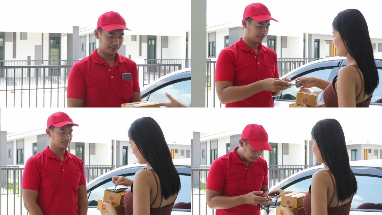 亚洲送货服务人员穿着红色制服，戴着红色帽子和面罩，处理纸板箱，送给屋前的女顾客。网购快递