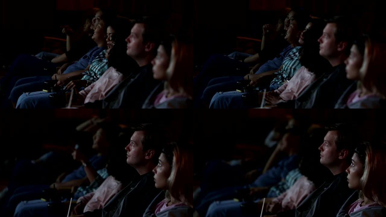 人们和家人一起坐在电影院看电影，幸福