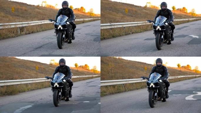 戴着头盔的男子在高速公路上骑着现代运动摩托车。摩托车手在乡间小路上骑摩托车。旅途中开车的人。自由和冒