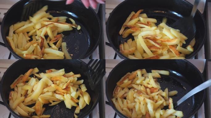 土豆在油锅里油炸。烹饪炸土豆。用厨房刮铲搅拌土豆片以防止燃烧