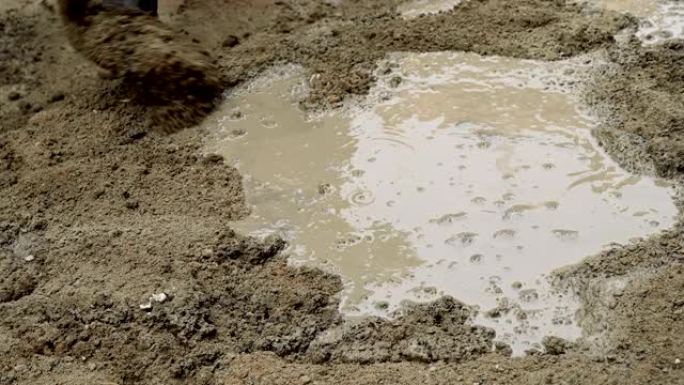 印度劳工用铲子搅拌水泥。