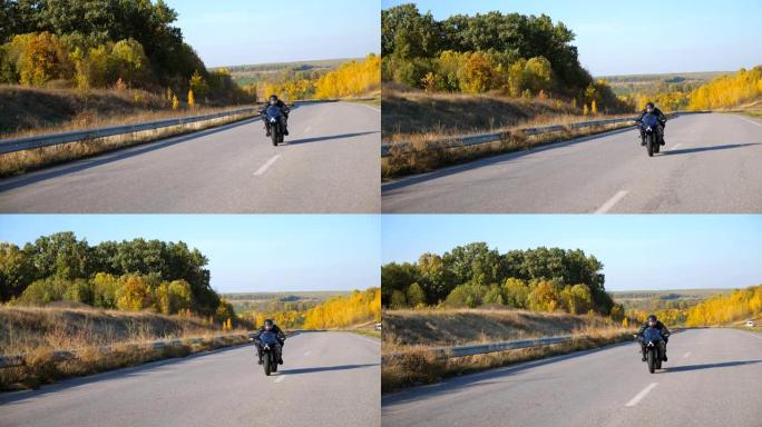戴着头盔的年轻人在高速公路上快速骑现代运动摩托车。摩托车手在乡间小路上骑摩托车。旅途中开车的人。自由