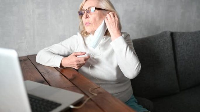 技术、老年和人的概念 -- 在冠状病毒冠状病毒19大流行期间，快乐的老年女性戴着口罩工作，在家用笔记