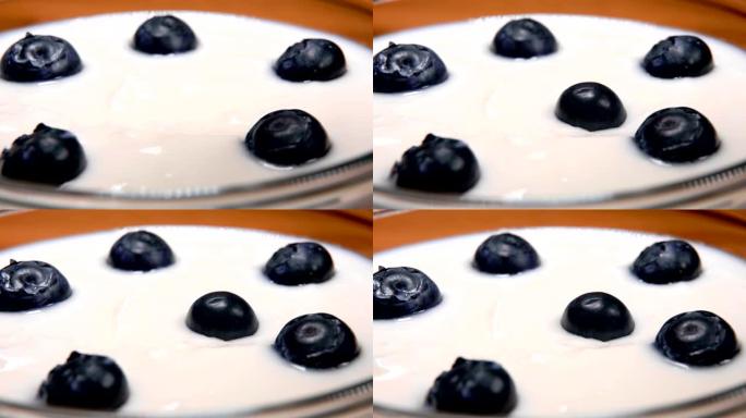大型蓝莓以慢动作掉落在奶油新鲜的酸奶上