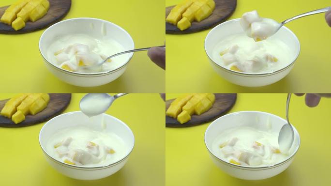 芒果掉入黄色桌子上的酸奶中