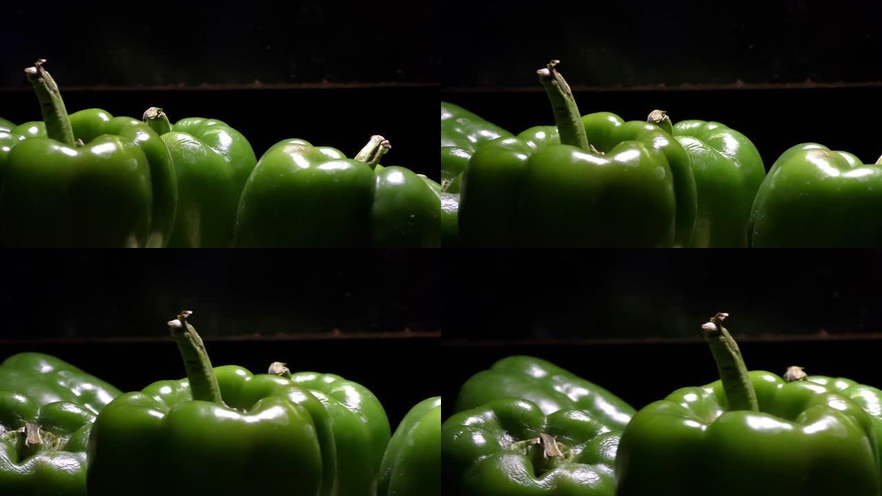 黑暗中的绿色辣椒，光线落在它们身上