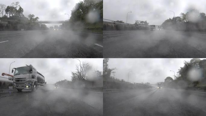 驾车穿越暴风雨的高速公路/后视图