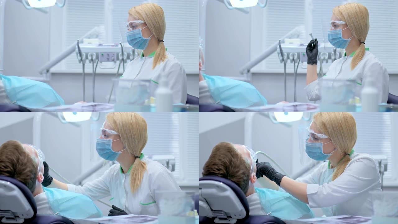 牙医从牙科单位采取钻头，并开始钻一颗牙齿，龋齿治疗的过程。牙科诊所的现代工具和设备。蛀牙治疗。