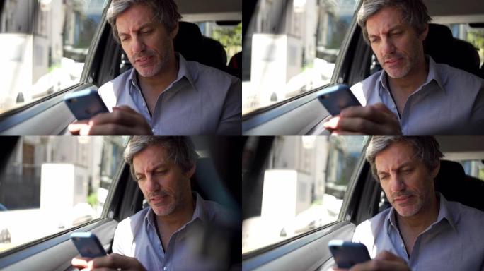 帅气的商人开车上班时在手机上发短信
