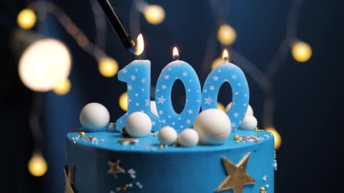 生日蛋糕编号100星星天空和月亮概念，蓝色蜡烛被打火机点燃，然后吹灭。如果需要，请在屏幕右侧复制空间