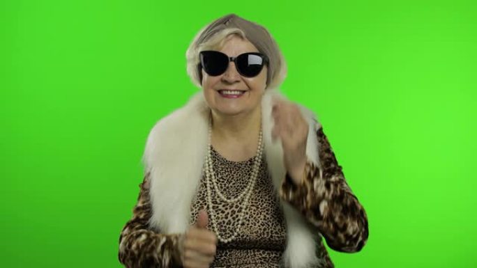 老式白人奶奶戴上太阳镜。色度键背景