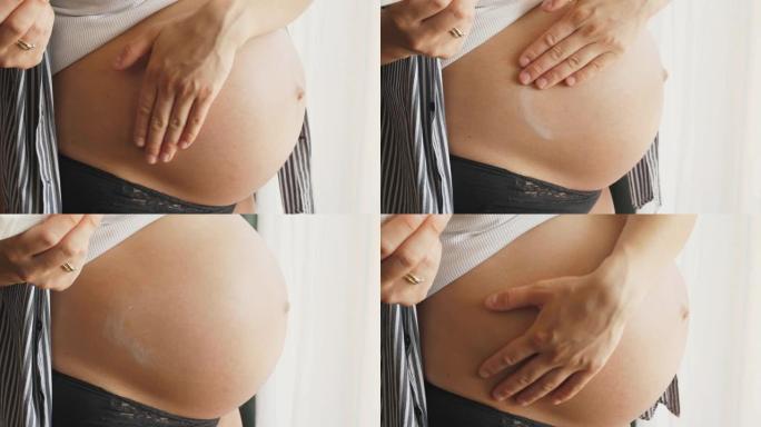 妇女润滑滋润怀孕的腹部与霜为妊娠纹