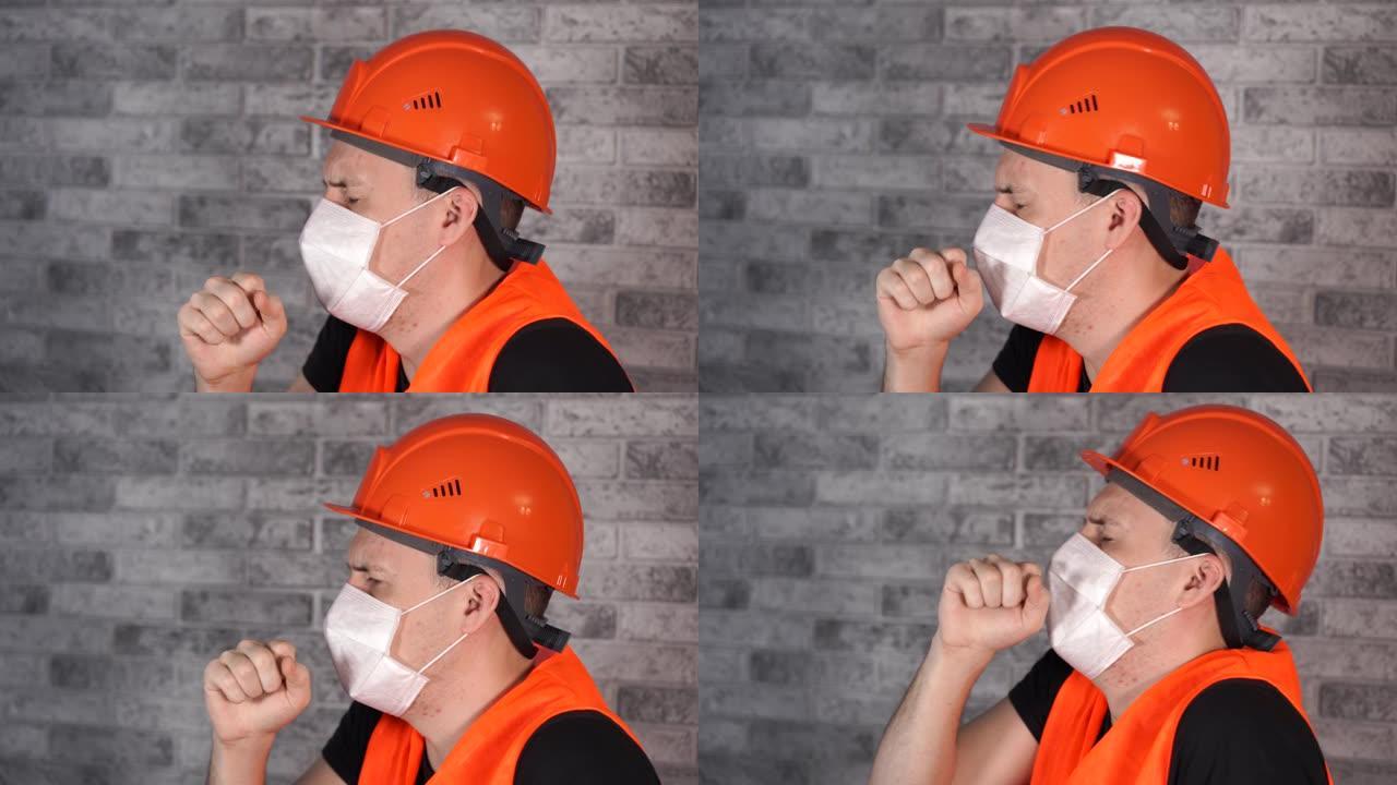穿着工作服和医用口罩的男性建筑工人在灰色砖墙的面部背景上咳嗽。感染威胁的概念