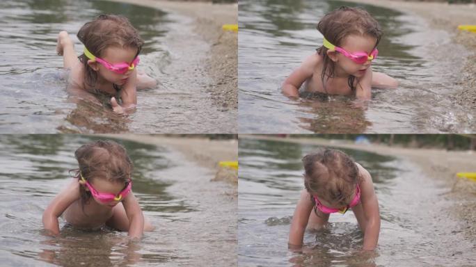可爱的小女孩，戴着潜水镜试图游泳