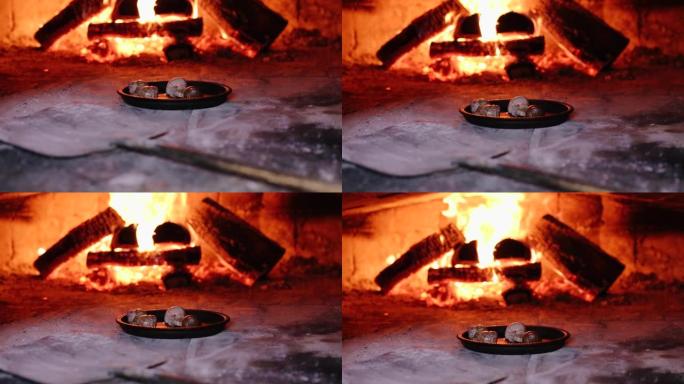 在餐厅厨房里用明火和燃烧的树林在加热烤箱中油炸烹饪蜗牛蜗牛