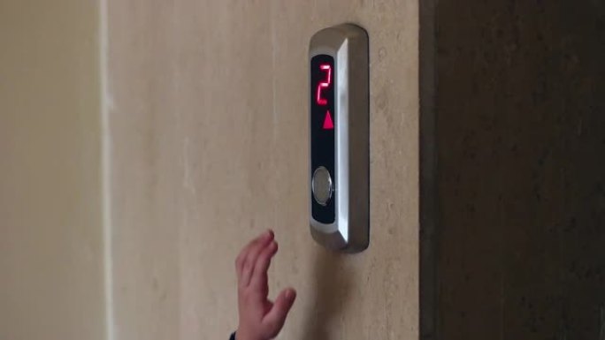 小孩的手指按电梯的下按钮